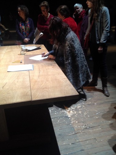 At the other end of the space, another performer is sitting with her back to the curtain writing nonstop, reflecting on what's happening and free-associating. The sound of her pencil scratching can also be heard over the radio broadcast. 