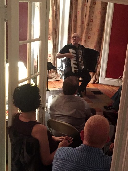 Guy Klucevek, the accordion master, in a home concert hosted by his longtime friend George Russell (below)